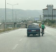 Hatay'da otomobile tutunarak giden bisikletlinin tehlikeli yolculuğu kamerada