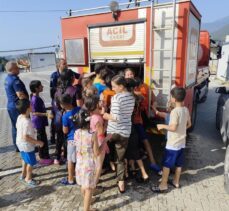 Hatay'da konteyner kentteki öğrenciler itfaiyenin sıktığı suyla serinledi